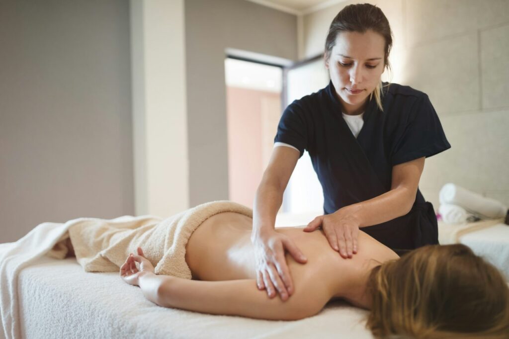Massage therapist massaging a woman's back