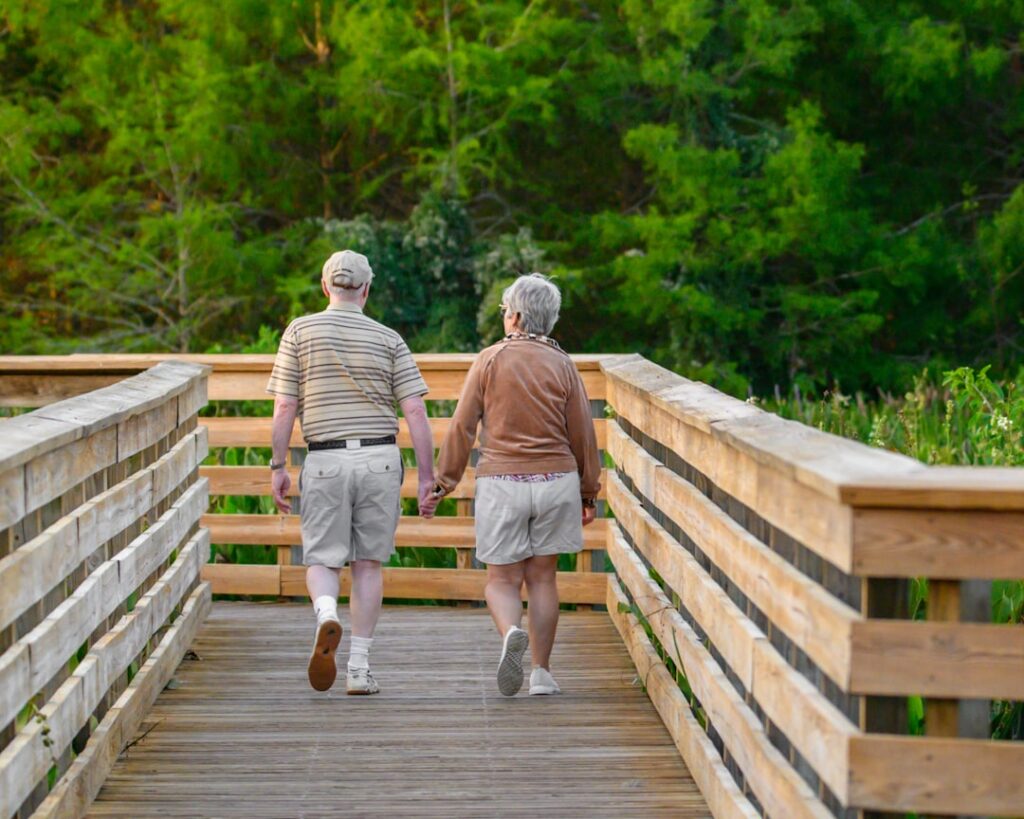 Two adults taking an easy walk across a bridge during an active recovery day
