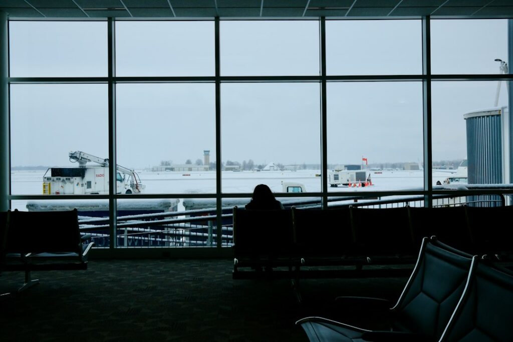 Traveler sitting by an airport window while using calm travel coping strategies