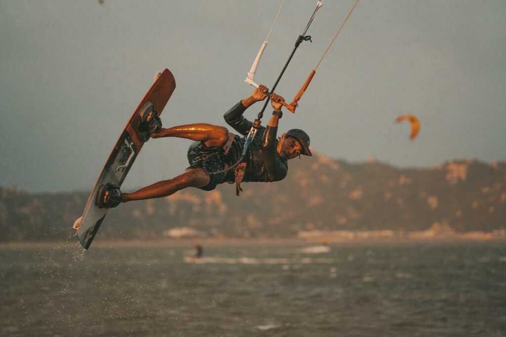 Kitesurfer holding the bar while riding a board across the water