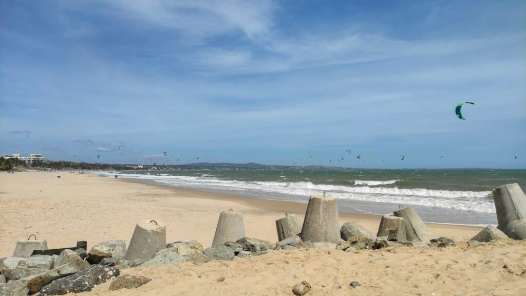 Several kitesurfers riding on the water beneath colorful kites; stock photograph
