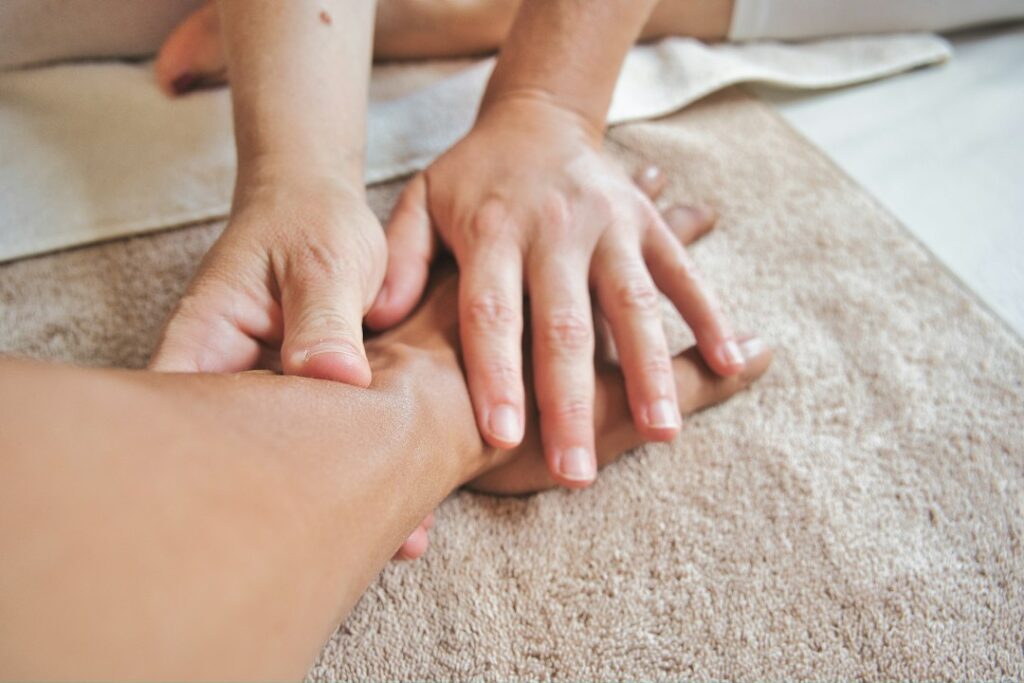 Hands receiving professional massage therapy