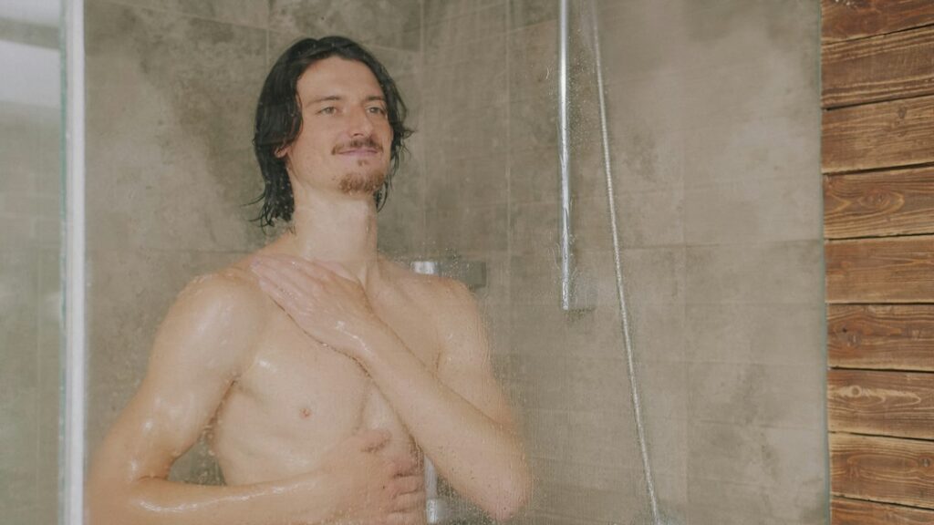 Adult taking a shower after exercise as part of a post-workout routine