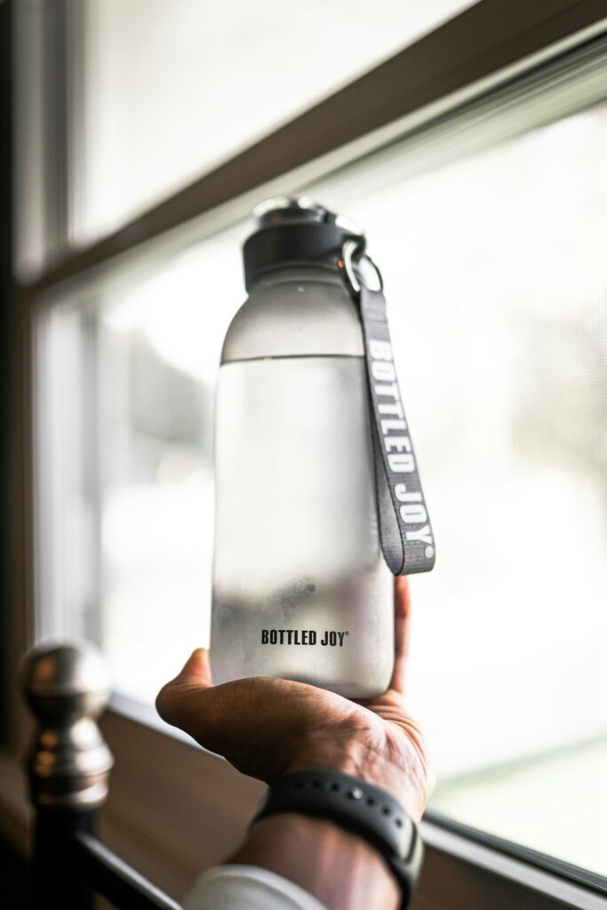 Traveler holding a water bottle, illustrating hydration and healthy travel habits